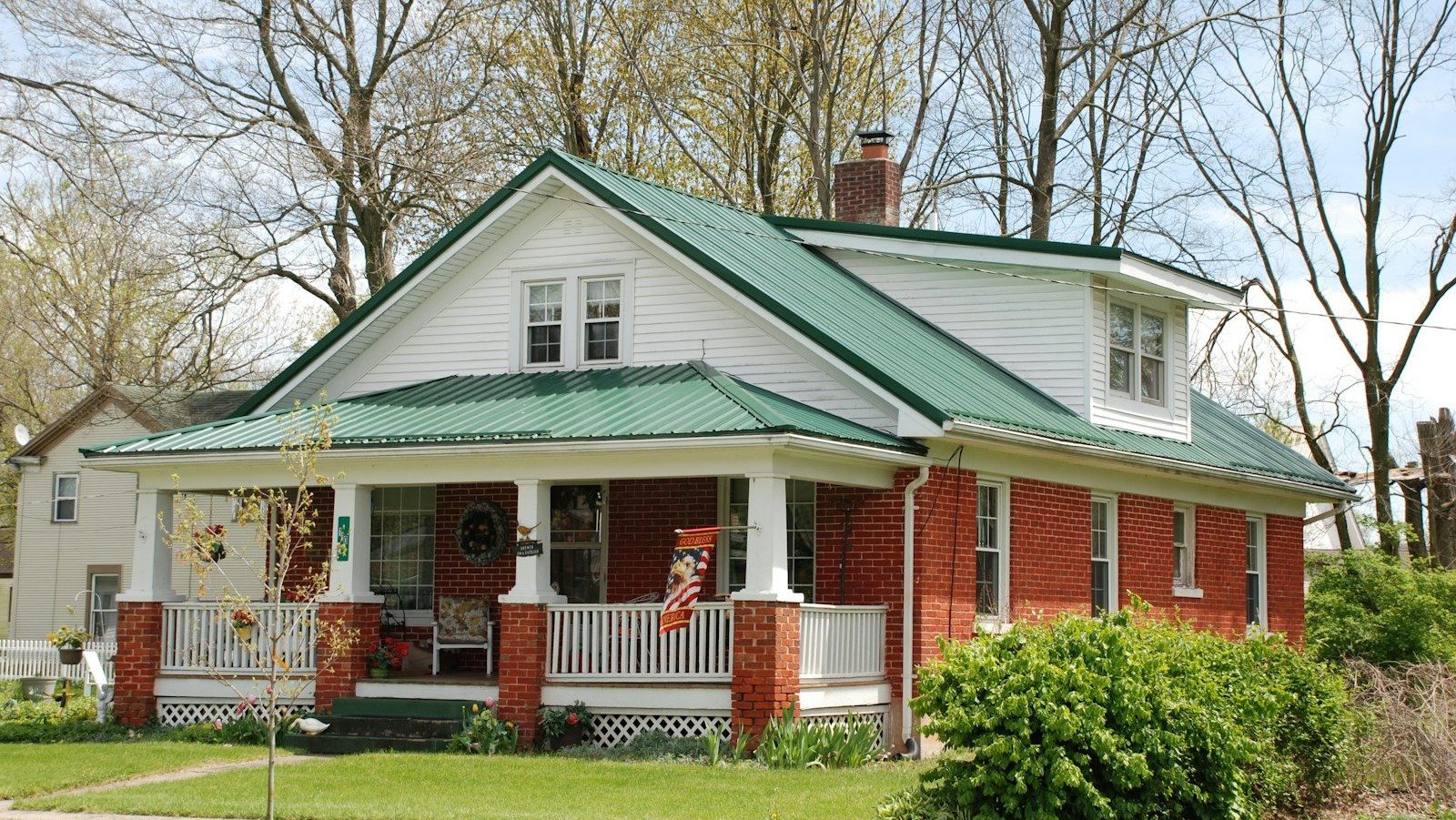 white and brown wooden house near green trees during daytime